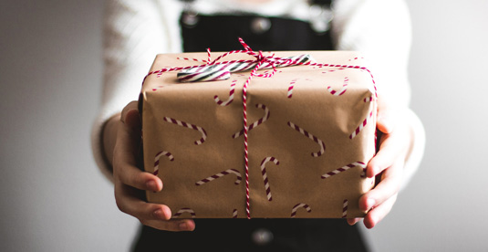 person holding out a wrapped present